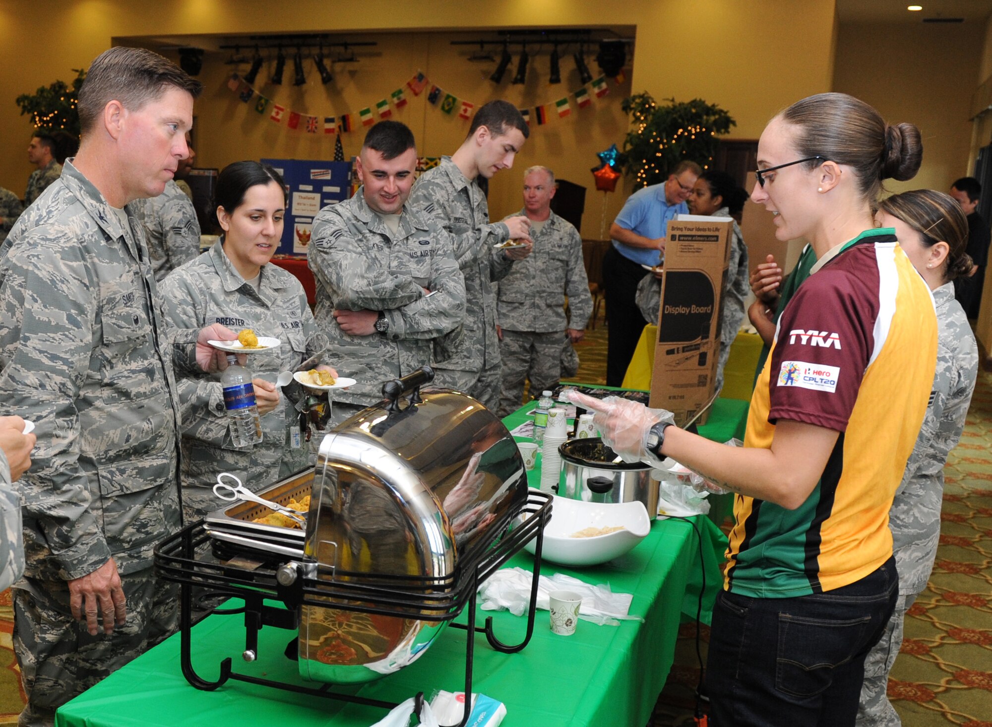 Staff Sgt. Lesli Pape, 81st Aerospace Medicine Squadron public health technician, discuss Guyana cuisine with Col. C. Mike Smith, 81st Training Wing vice commander, and other Keesler personnel during Diversity Day at the Bay Breeze Event Center Sept. 13, 2016, on Keesler Air Force Base, Miss. The cultural celebration included food sampling and information booths about countries around the world and other special emphasis groups. (U.S. Air Force photo by Kemberly Groue/Released)