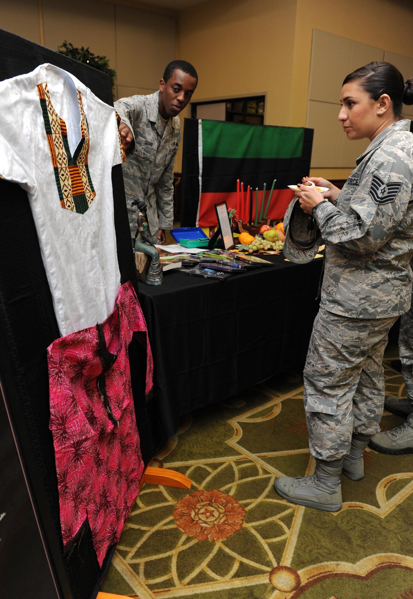 Senior Airman Martin Githui, 81st Contracting Squadron contracting specialist, shows clothing worn in Kenya and Nigeria to Tech. Sgt. Carleen Wallace, 81st Aerospace Medicine Squadron Base Operation Medicine Cell flight chief, during Diversity Day at the Bay Breeze Event Center Sept. 13, 2016, on Keesler Air Force Base, Miss. The cultural celebration included food sampling and information booths about countries around the world and other special emphasis groups. (U.S. Air Force photo by Kemberly Groue/Released)