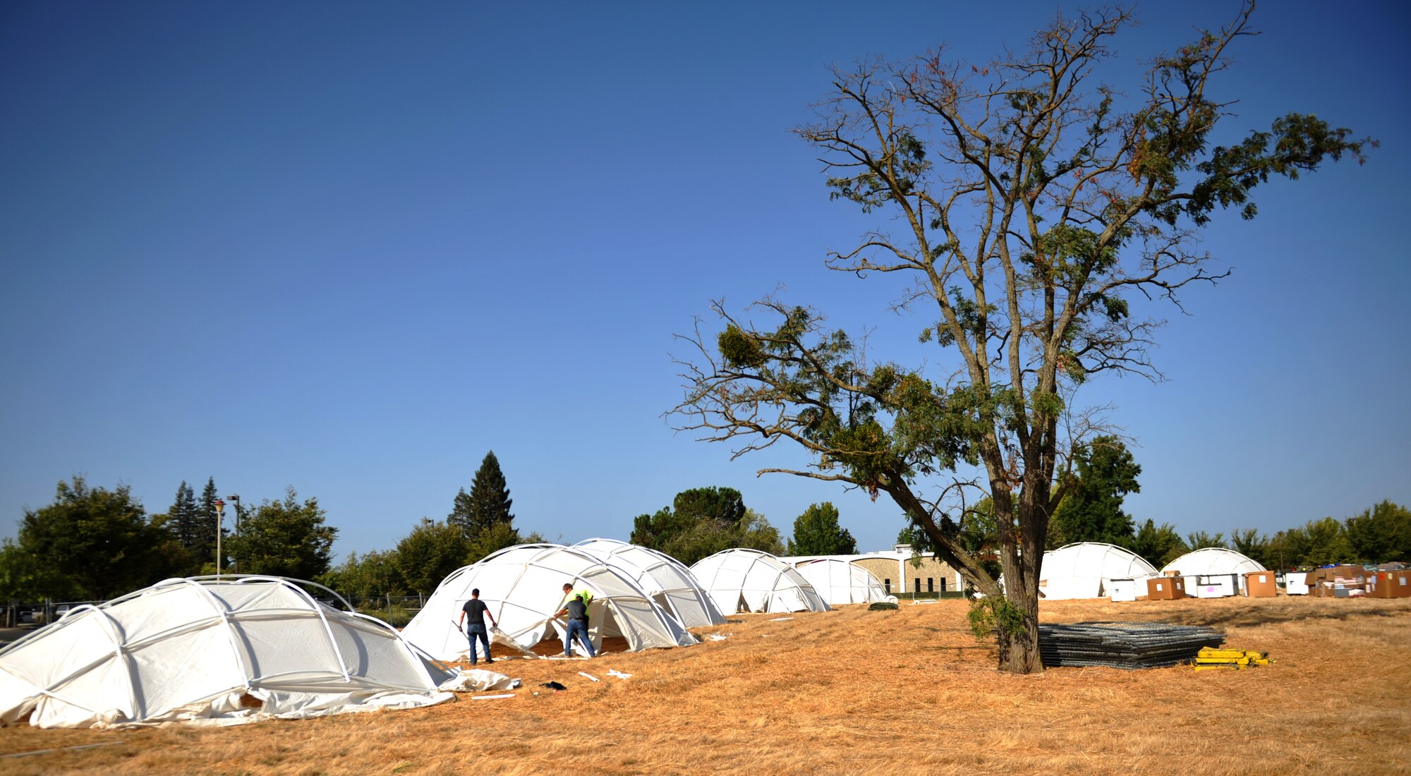 Airmen and civilian volunteers construct tents for the three-day Sacramento Stand Down event Sept. 13, 2016, at Rancho Cordova, California. The Stand Down event is in its 25th year and provides shelter and multi-faceted assistance to homeless veterans in the Sacramento area. Last year 270 homeless veterans were helped and 80 found housing through the event. (U.S. Air Force photo/Staff Sgt. Jeffrey M. Schultze)