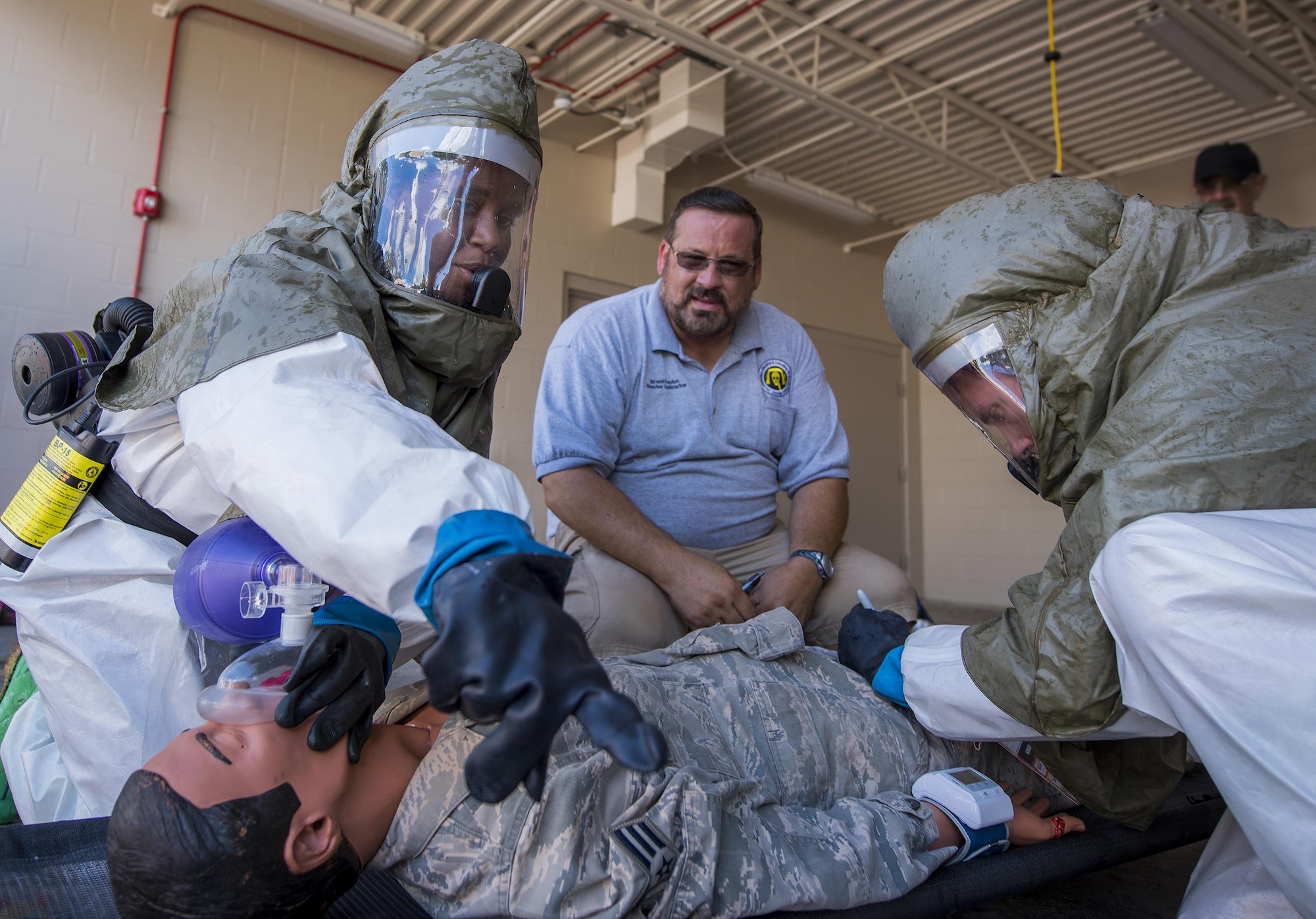 Airmen perform life-saving procedures on a simulated victim during a decontamination procedures exercise at the Hospital Sept. 15 at Eglin Air Force Base, Fla.  The 96th Medical Group Airmen worked quickly to erect and set up a decontamination tent with running water and drainage and donned their protective gear.  Despite the heat, the team was fully set up and ready to receive patients in under 12 minutes. (U.S. Air Force photo/Samuel King Jr.)