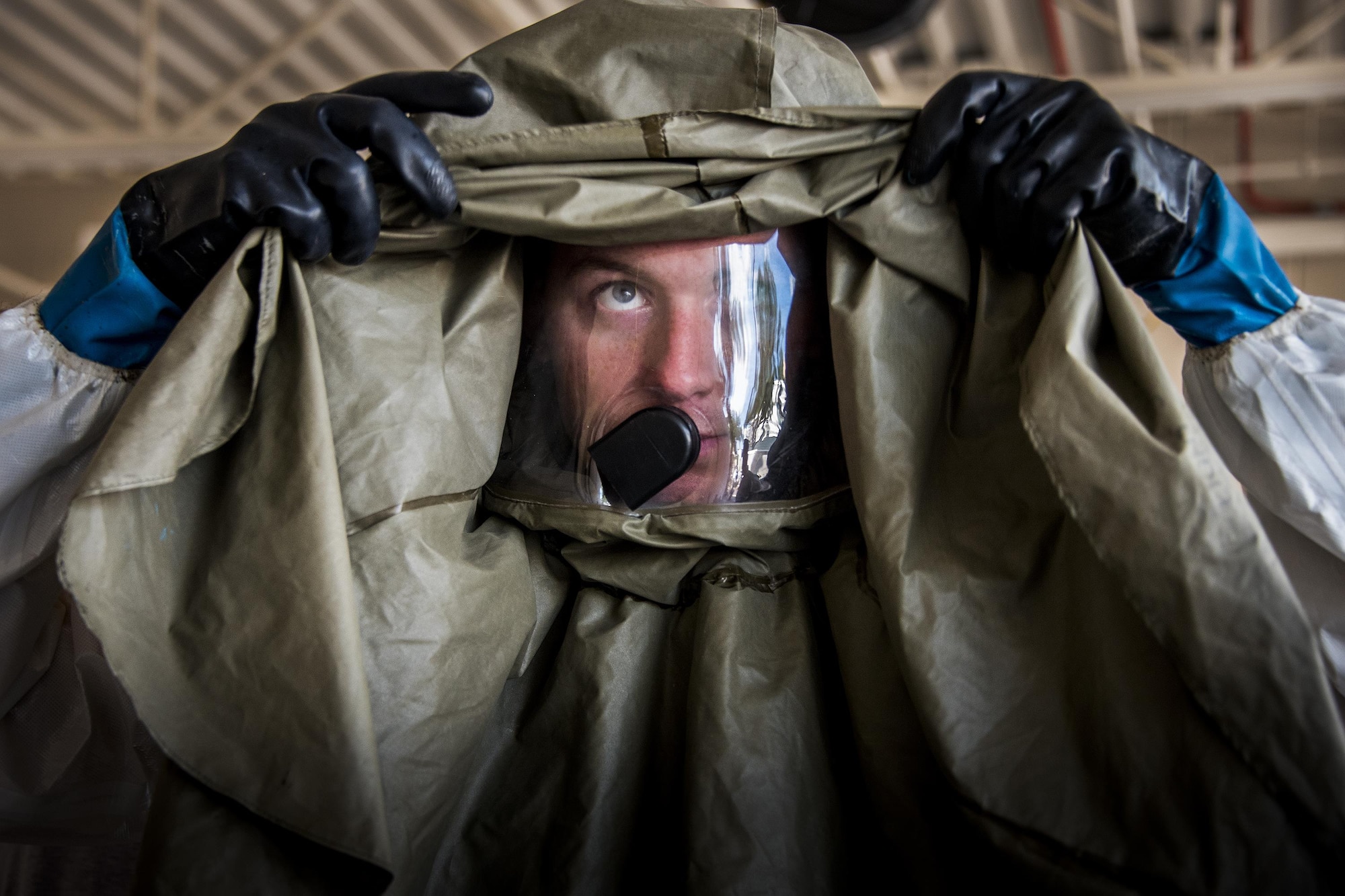 Airman 1st Class David Capperino pulls his protective head gear on during a decontamination procedures exercise at the Hospital Sept. 15 at Eglin Air Force Base, Fla.  The 96th Medical Group Airmen worked quickly to erect and set up a decontamination tent with running water and drainage and donned their protective gear.  Despite the heat, the team was fully set up and ready to receive patients in under 12 minutes. (U.S. Air Force photo/Samuel King Jr.)