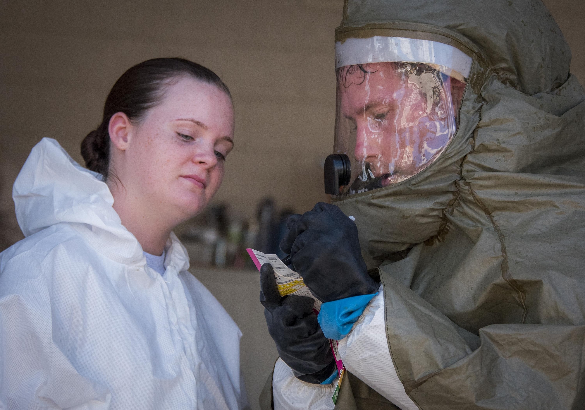 Senior Airman Robert Muir, 96th Medical Group, takes down medical information of a simulated victim during the decontamination procedures exercise at the Hospital Sept. 15 at Eglin Air Force Base, Fla.  The Airmen worked quickly to erect and set up a decontamination tent with running water and drainage and donned their protective gear.  Despite the heat, the team was fully set up and ready to receive patients in under 12 minutes. (U.S. Air Force photo/Samuel King Jr.)