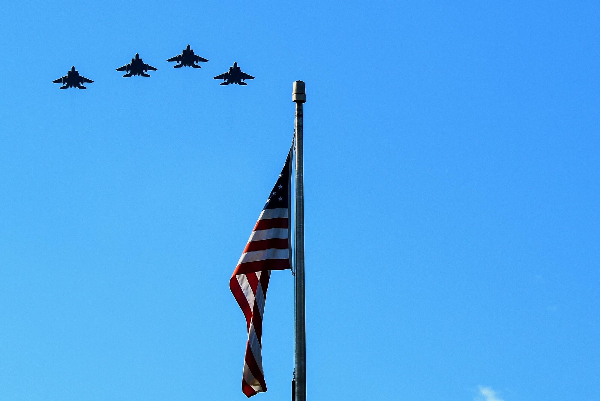 Four F-15E Strike Eagle aircraft from the 334th Fighter Squadron perform a missing man formation flyover during a Prisoners of War/Missing in Action Remembrance ceremony, Sept. 15, 2016, at Seymour Johnson Air Force Base, North Carolina. Gaspar Gonzalez, a former Korean War Prisoner of War and U.S. Army Green Beret, was the guest speaker during the ceremony and spoke about his 22 days in captivity by the Chinese during the Korean War. (U.S. Air Force photo by Airman Shawna L. Keyes) 