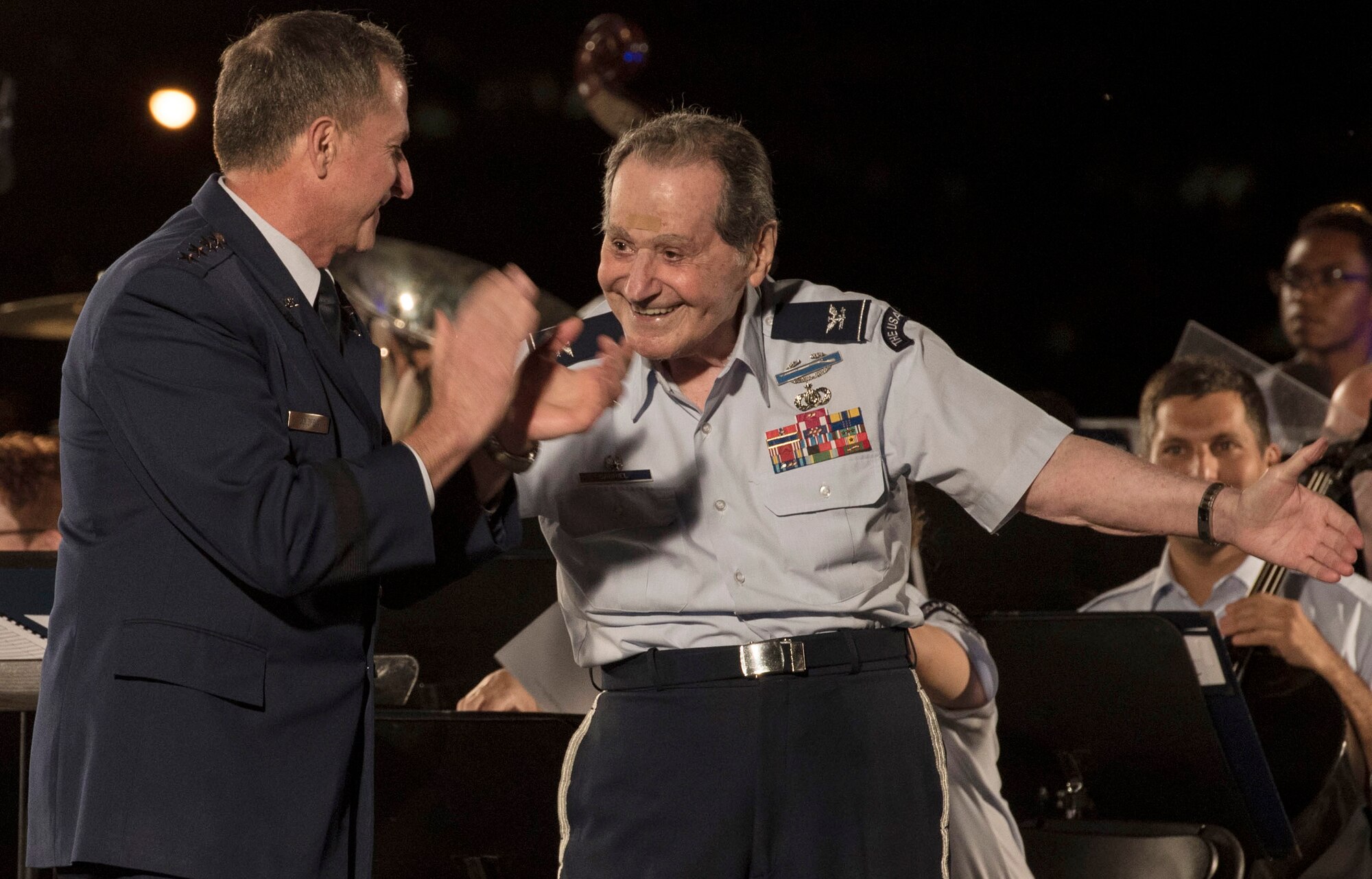 Retired Col. Arnold D. Gabriel, former U.S. Air Force Band commander, takes a bow next to Gen. David L. Goldfein, Chief of Staff of the Air Force, after conducting a performance during the POW/MIA and Air Force Birthday event at the Air Force Memorial in Arlington, Va., Sept. 16, 2016. Gabriel, an Air Force veteran who served in World War II and has two bronze stars, was honored at the event. 