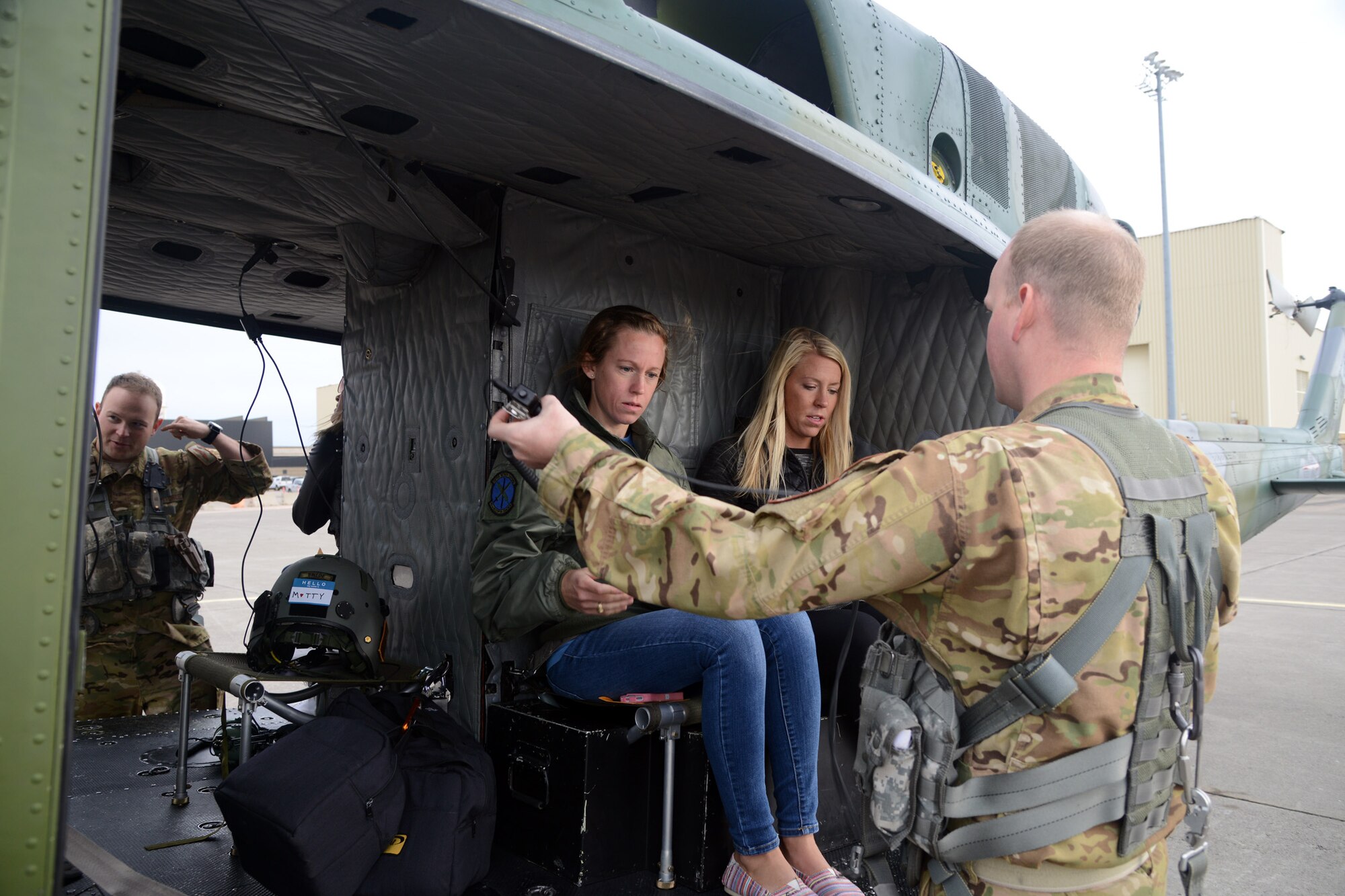 Kristen Burchell and Kristie Barkauskas, 40th Helicopter Squadron spouses receive pre-flight instructions from Staff Sgt. Matt Tidball, 40th HS UH-1N Iroquois flight engineer Sept. 17, 2016 at Malmstrom Air Force Base, Mont. Burchell and Barkauskas were two of 31 spouses that flew during a spouses orientation event. (U.S. Air Force photo/Staff Sgt. Delia Marchick)