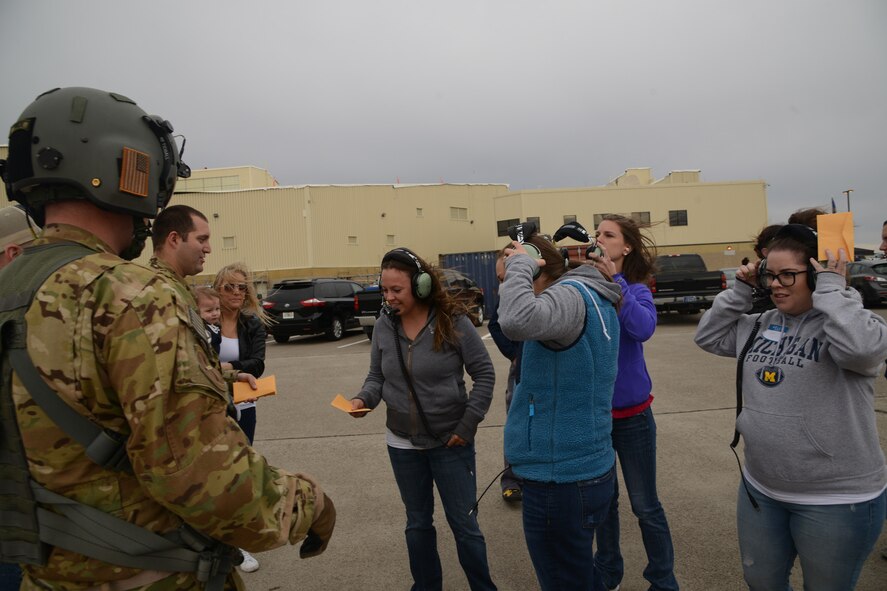 Spouses from 40th Helicopter Squadron receive hearing protection, headsets and motion sickness bags from Staff Sgts. Matthew Tidball and Joshua Makepeace, 40th HS UH-1N Iroquois flight engineers Sept. 17, 2016 at Malmstrom Air Force Base, Mont. Thirty-one 40th HS spouses experienced the full pre-flight preparations and briefings before flying. (U.S. Air Force photo/Staff Sgt. Delia Marchick)