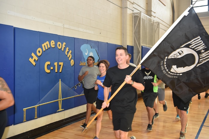 U.S. Air Force Col. Jeffrey Nelson, vice commander of the 437th Airlift Wing, runs the POW/MIA flag at the Air Base fitness center September 15, 2016, at Joint Base Charleston, South Carolina. Every year, members from the base participate in a 24-hour vigil run, a luncheon to honor prisoners of war and those that are missing in action, as well as a formal retreat ceremony. 