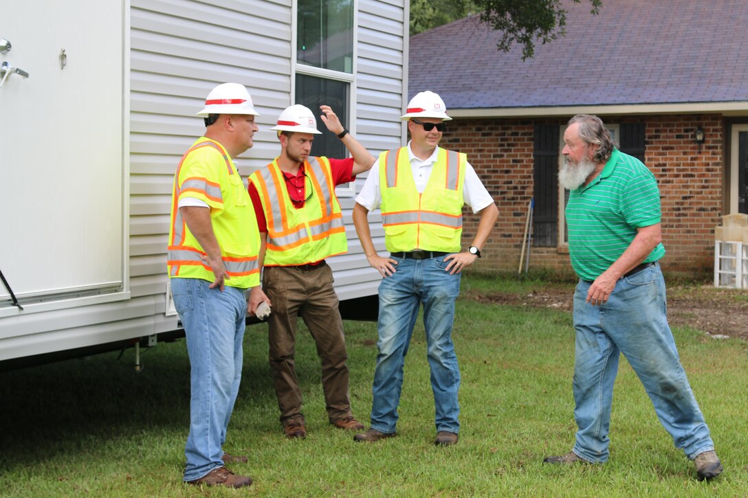 Ron Saunders (L), Brian MacEachern (C) and Mike Barbour (L), quality assurance specialists from the Huntington District, U.S. Army Corps of Engineers talk with a contractor after the delivery of a Mobile Housing Unit to a property owner in Denham Springs, La.