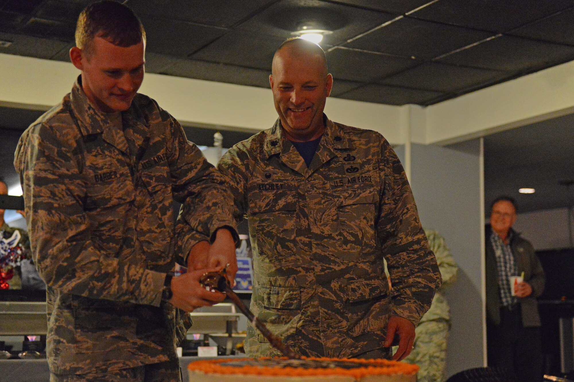 Airman Basic Zachary Barber, 773rd Logistics Readiness Squadron, parachute rigger, and Air Force Lt. Col. James Atchley, 673d Contracting Squadron, commander cut the cake Sept. 16 at Permafrost Pub, Joint Base Elmendorf-Richardson in celebration of the Air Force's 69th birthday. It is customary for the Airmen with the least time in service and the Airman with the most time in service present to cut the cake. 
