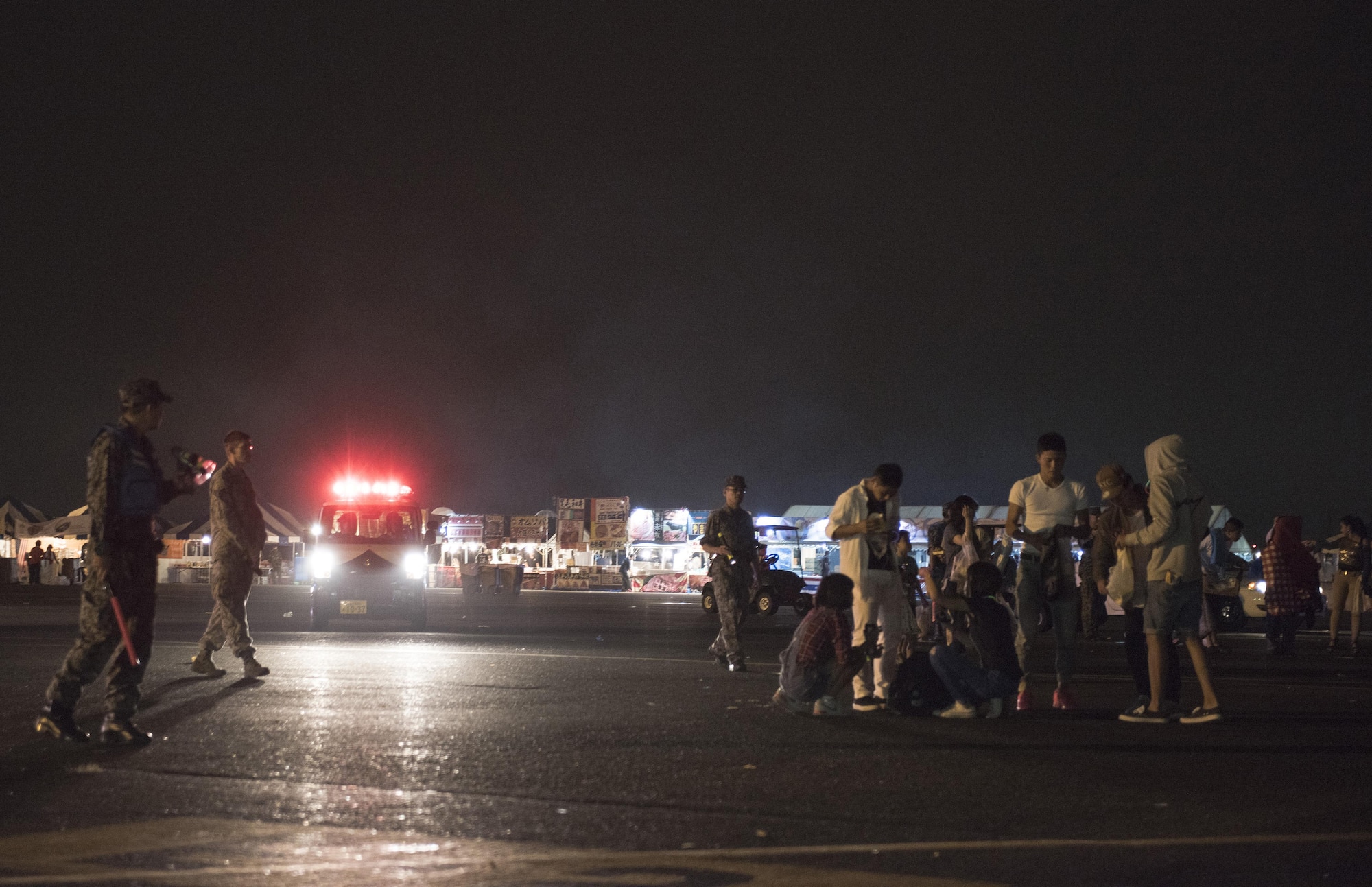 Members of the 374th Security Forces Squadron and the Japan Air-Self Defense Force usher the last remaining attendees off the festival grounds during the 2016 Japanese-American Friendship Festival at Yokota Air Base, Japan, Sept. 18, 2016. The festival is hosted on Yokota’s flightline; the quicker it is cleared, the sooner the flightline can return to operational normalcy. (U.S. Air Force photo by Staff Sgt. Cody H. Ramirez/Released)
