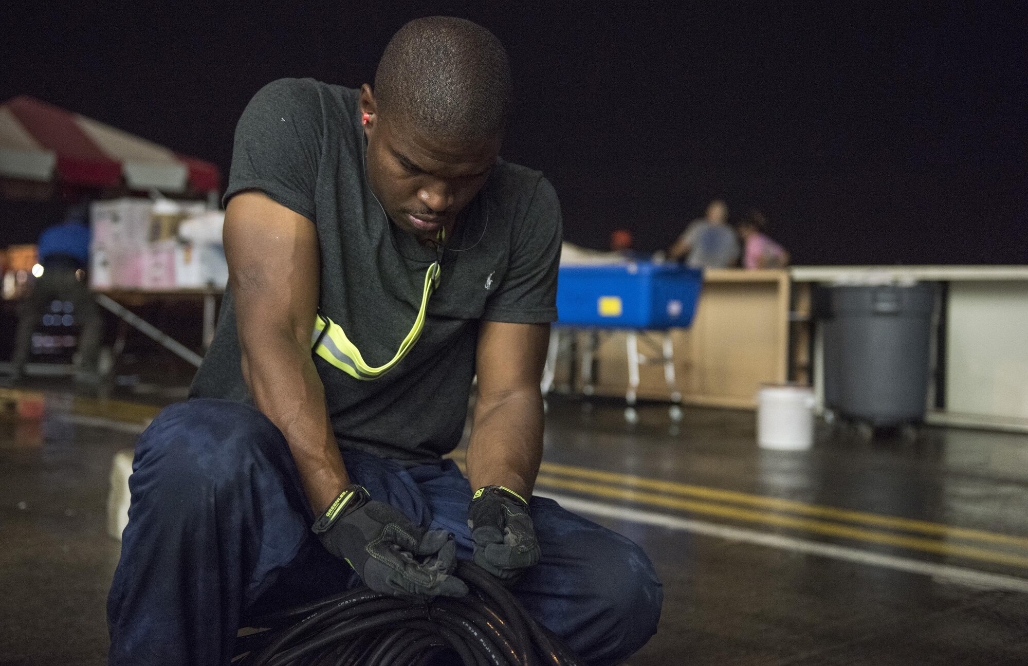 Staff Sgt. Quintin Robinson, 374th Civil Engineer Squadron electrician, coils an electrical cord used during the 2016 Japanese-American Friendship Festival at Yokota Air Base, Japan, Sept. 18, 2016. Thousands of feet of electrical cords were used to power vendor stands during the festival; the 374 CES engineer shop installs the cords before the festival and removes them the closing night. (U.S. Air Force photo by Staff Sgt. Cody H. Ramirez/Released)