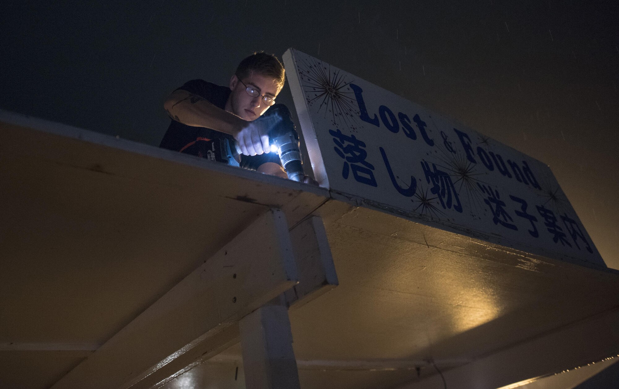 Senior Airman Miles Brickell, 374th Civil Engineer Squadron structures journeyman, unscrews a sign from a booth after the 2016 Japanese-American Friendship Festival at Yokota Air Base, Japan, Sept. 18, 2016. The structures shop had their booths broken down within two hours of the festival closure, assisting to return the flightline to full operational status. (U.S. Air Force photo by Staff Sgt. Cody H. Ramirez/Released)