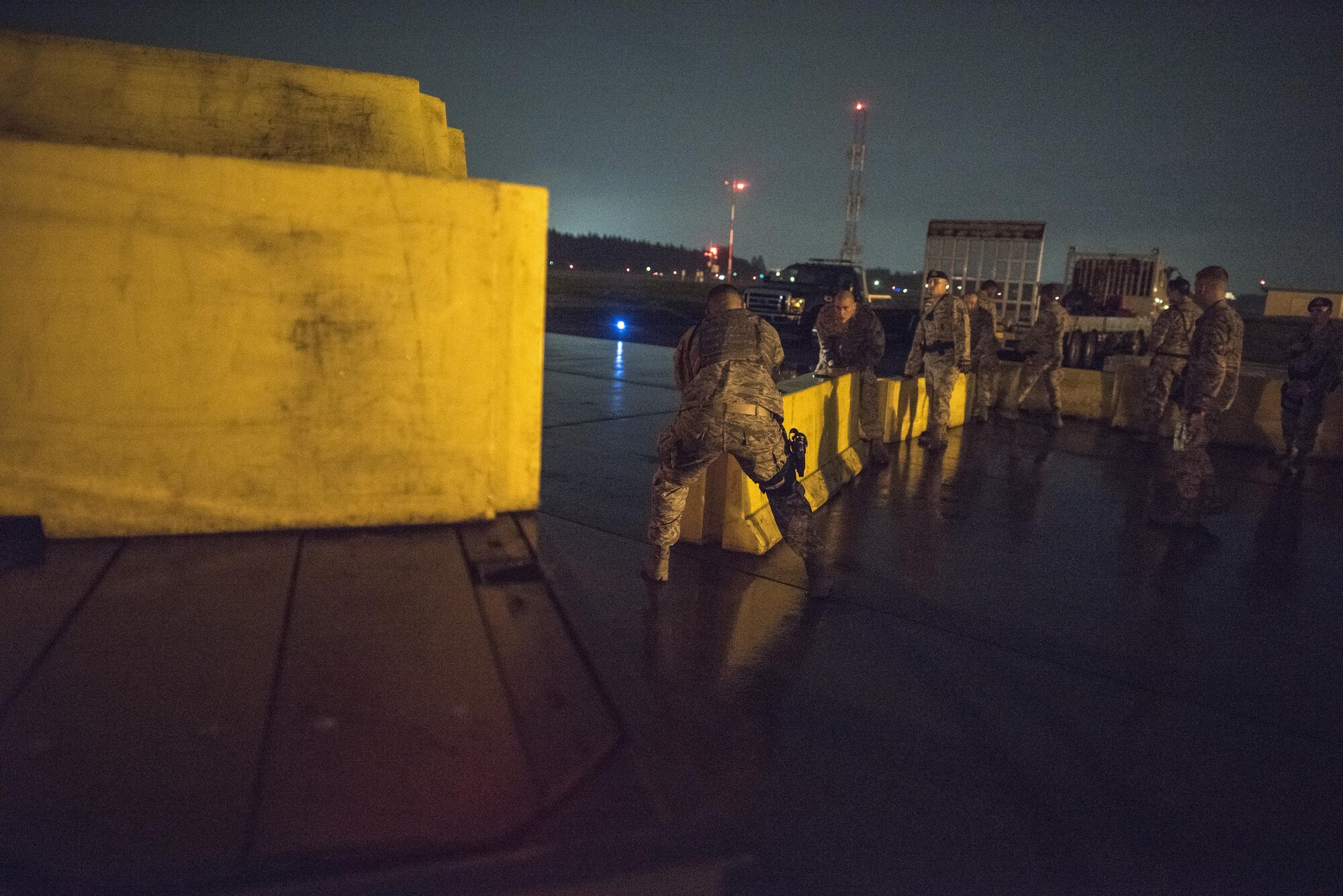 Airmen with the 374th Security Forces Squadron load barriers onto a truck bed after the 2016 Japanese- American Friendship Festival at Yokota Air Base, Japan, Sept. 18, 2016. The barriers were used to create a perimeter between the runway and sections of the flightline used as the festival grounds. (U.S. Air Force photo Staff Sgt. Cody H. Ramirez/Released)