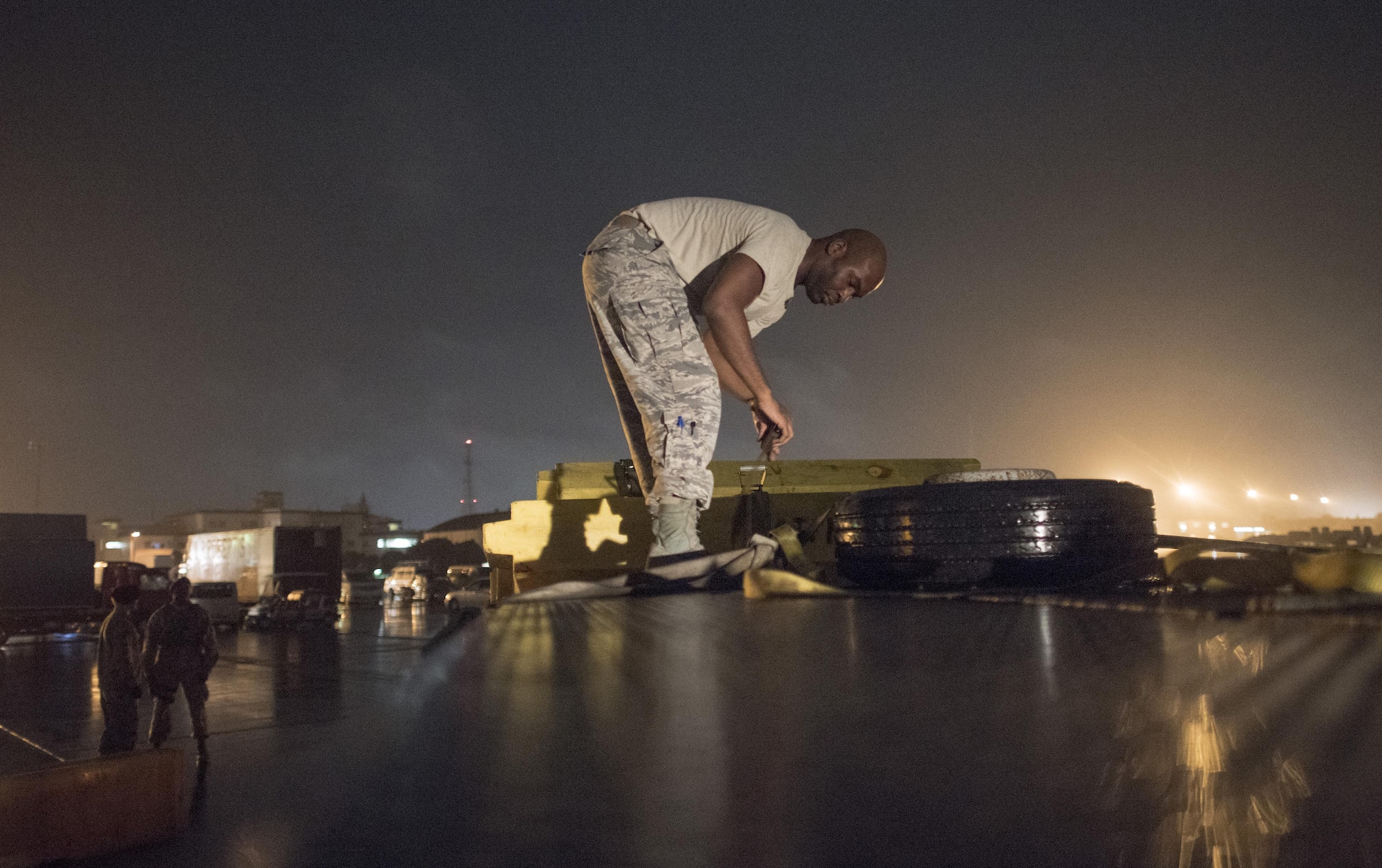 Staff Sgt. Rahmon Harrell, 374th Logistics Readiness Squadron vehicle operator, unrolls a strap to secure barriers onto a truck bed after the 2016 Japanese-American Friendship Festival at Yokota Air Base, Japan, Sept. 18, 2016. At the conclusion of the festival, Airmen worked to breakdown booths, remove wiring and barriers and clean the grounds. (U.S. Air Force photo by Staff Sgt. Cody H. Ramirez/Released)