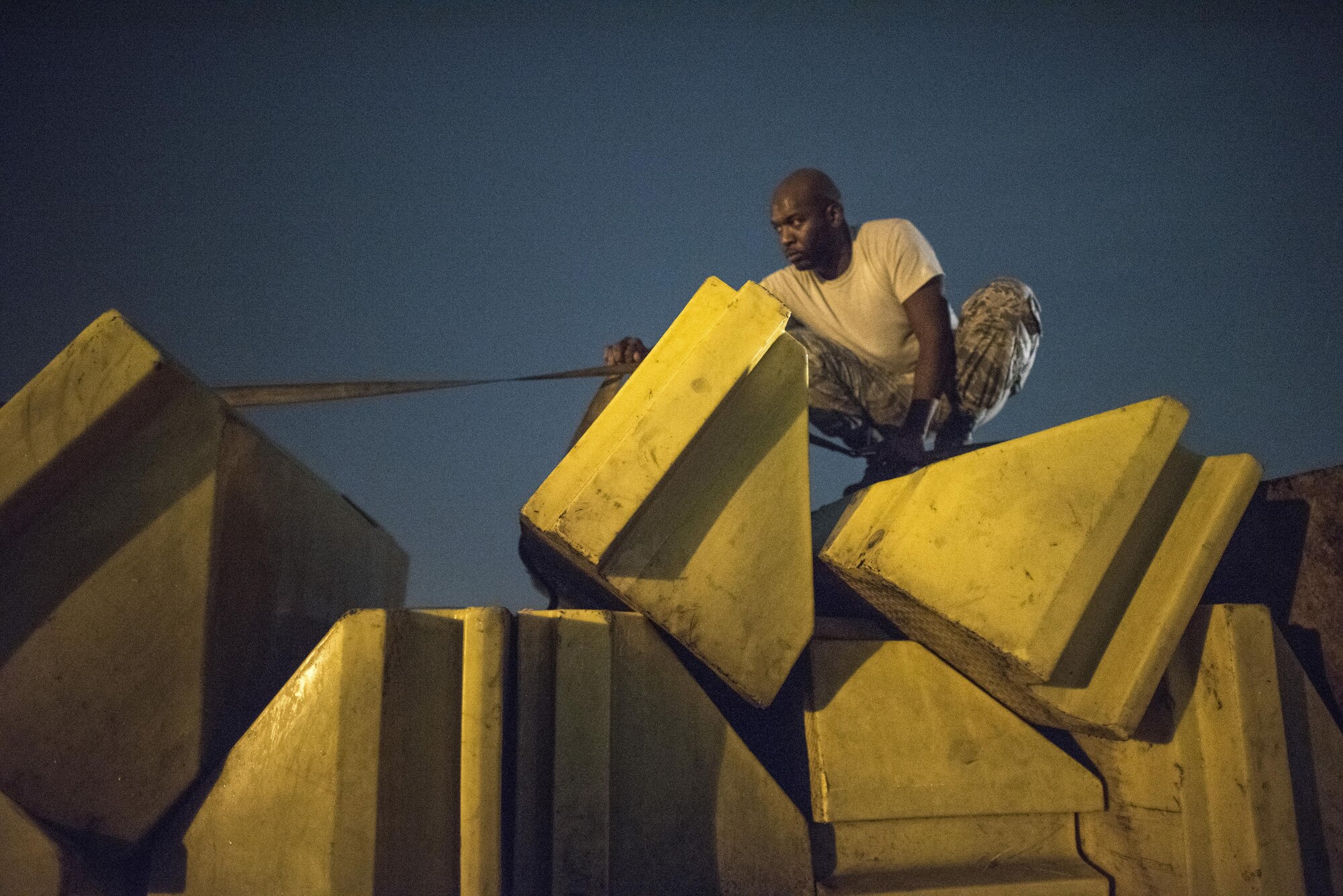 Staff Sgt. Rahmon Harrell, 374th Logistics Readiness Squadron vehicle operator, unrolls a strap to secure barriers onto a truck bed after the 2016 Japanese-American Friendship Festival at Yokota Air Base, Japan, Sept. 18, 2016. At the conclusion of the festival, Airmen worked to breakdown booths, remove wiring and barriers and clean the grounds. (U.S. Air Force photo by Staff Sgt. Cody H. Ramirez/Released)