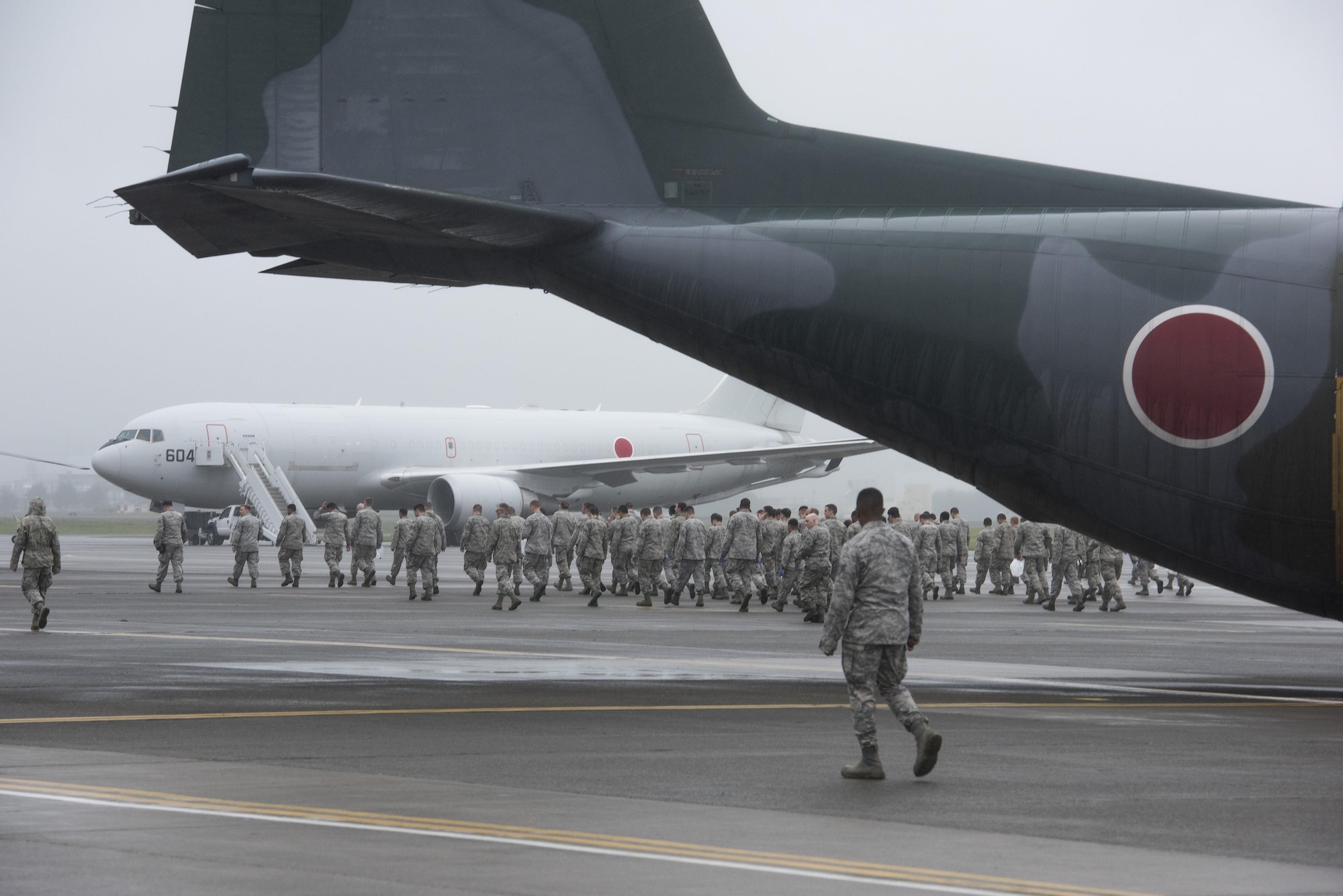 Airmen conduct a foreign-debris walk over the flightline at Yokota Air Base, Japan, Sept. 19, 2016, passing Japanese Air Self-Defense Force aircraft that came to the base to participate in the 2016 Japanese-American Friendship Festival. Airmen spread throughout areas of the base to pick up foreign debris left over by the festival, which attracted more than 135,000 people to the base. (U.S. Air Force photo by Staff Sgt. Cody H. Ramirez/Released)