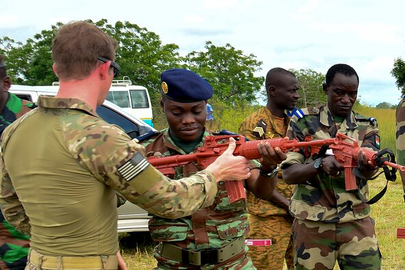 Staff Sgt. Jake Van Dyke (left), a 435th Security Forces Squadron contingency response fire team member, helps a Benin airman with his weapon during the African Partnership Flight in Accra, Ghana, Sept. 14, 2016. APF is a transparent working environment between U.S. and African partner nations that builds trust and cooperation to achieve common solutions. (U.S. Air Force photo/Staff Sgt. Stephanie Longoria)