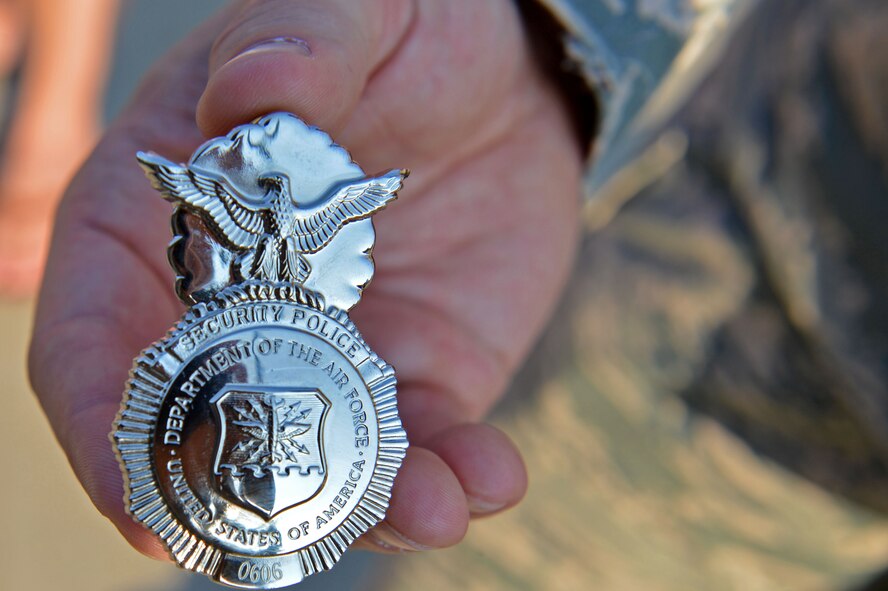 U.S. Air Force Tech. Sgt. Kevin Arndt, 20th Security Forces Squadron anti-terrorism program noncommissioned officer in charge, holds Jake Pritchard’s 20th SFS honorary defender badge at Shaw Air Force Base, S.C., Sept. 9, 2016. Lt. Col. Garon Shelton, 20th SFS commander, assigned Pritchard’s badge number and retired it at the end of the event. (U.S. Air Force photo by Airman 1st Class Christopher Maldonado)