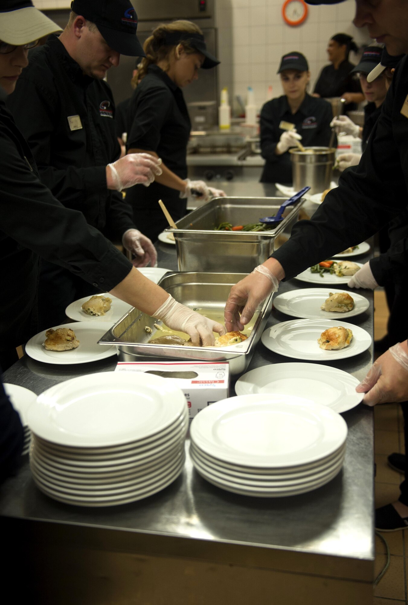 Kitchen staff members prepare plates with food during the Air Force Ball at Club Eifel on Spangdahlem Air Base, Germany, Sept. 17, 2016. More than 300 members attended the annual event commemorating the Air Force’s birthday. The celebration included the Singing Sabers, a guest speaker, a three course formal dinner and dancing. (U.S. Air Force photo by Airman 1st Class Preston Cherry/Released)
