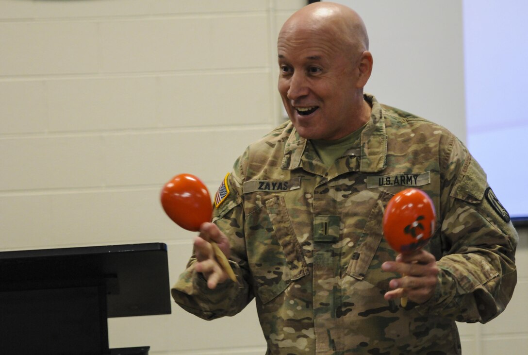 CW5 Miguel Zayas, a Caguas, Puerto Rico native and G36 senior technical advisor, and MSG Marland Williams, the G1 noncommissioned officer in charge, both from the 335th Signal Command (Theater), discuss how to properly play the maracas during the Equal Opportunity Observance in East Point, Georgia Sept. 18, 2016. During battle assembly weekend, the Equal Opportunity Office conducted its annual observance of National Hispanic Heritage Month. (U.S. Army photo by Sgt. Stephanie A. Hargett) (Released)