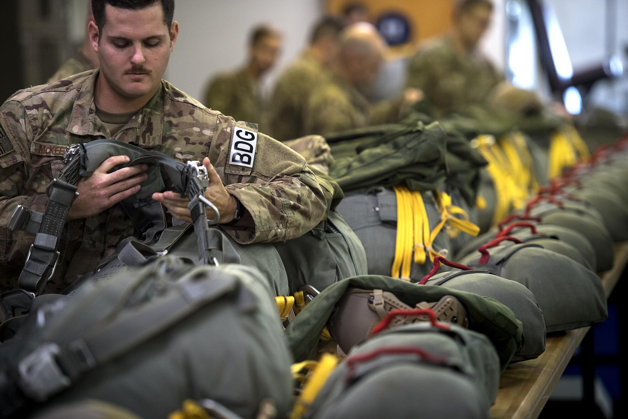 U.S. Air Force Senior Airman Nicholas McKeehan, 823d Base Defense Squadron, dons a parachute prior to participating in a static-line jump, Sept. 16, 2016, at Moody Air Force Base, Ga. Prior to each jump, a jumpmaster conducts an inspection to ensure each jumper’s parachute is properly prepared. (U.S. Air Force photo by Staff Sgt. Ryan Callaghan)