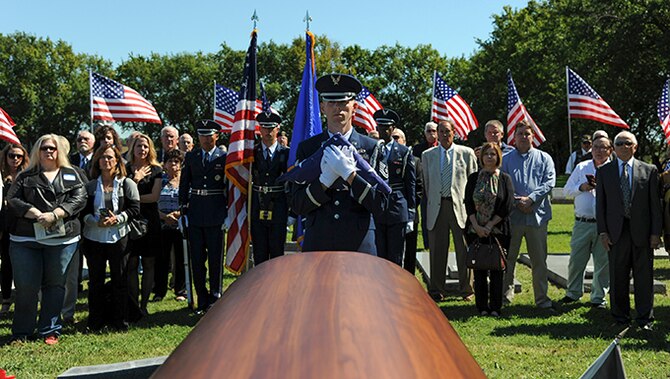 Tech. Sgt. Bobby McCrary, honor guard NCO in charge, holds a folded American flag before presenting it to the sister of Maj. Dean Klenda, an F-105 Thunderchief pilot who was listed as missing in action during the Vietnam War, Sept. 17, 2016, at St. John Nepomucene Church in Pilsen, Kan. Klenda was laid to rest exactly 51 years after his aircraft went down in 1965 in North Vietnam. His remains were located and verified by the Defense POW/MIA Accounting Agency. (U.S. Air Force photo/Airman 1st Class Jenna Caldwell)