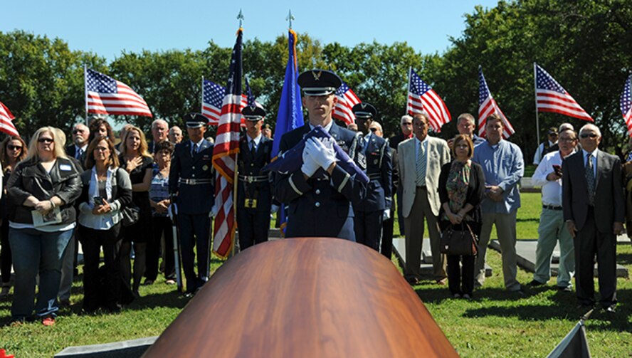 Tech. Sgt. Bobby McCrary, honor guard NCO in charge, holds a folded American flag before presenting it to the sister of Maj. Dean Klenda, an F-105 Thunderchief pilot who was listed as missing in action during the Vietnam War, Sept. 17, 2016, at St. John Nepomucene Church in Pilsen, Kan. Klenda was laid to rest exactly 51 years after his aircraft went down in 1965 in North Vietnam. His remains were located and verified by the Defense POW/MIA Accounting Agency. (U.S. Air Force photo/Airman 1st Class Jenna Caldwell)
