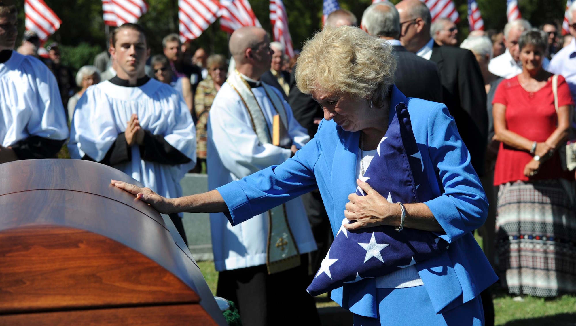 Deanna Klenda, the sister of Maj. Dean Klenda, an F-105 Thunderchief pilot who was listed as missing in action during the Vietnam War, says goodbye to her brother at his funeral, Sept. 17, 2016, at St. John Nepomucene Church in Pilsen, Kan. Klenda was laid to rest exactly 51 years after his aircraft went down in 1965 in North Vietnam. His remains were located and verified by the Defense POW/MIA Accounting Agency. (U.S. Air Force photo/Airman 1st Class Jenna Caldwell)