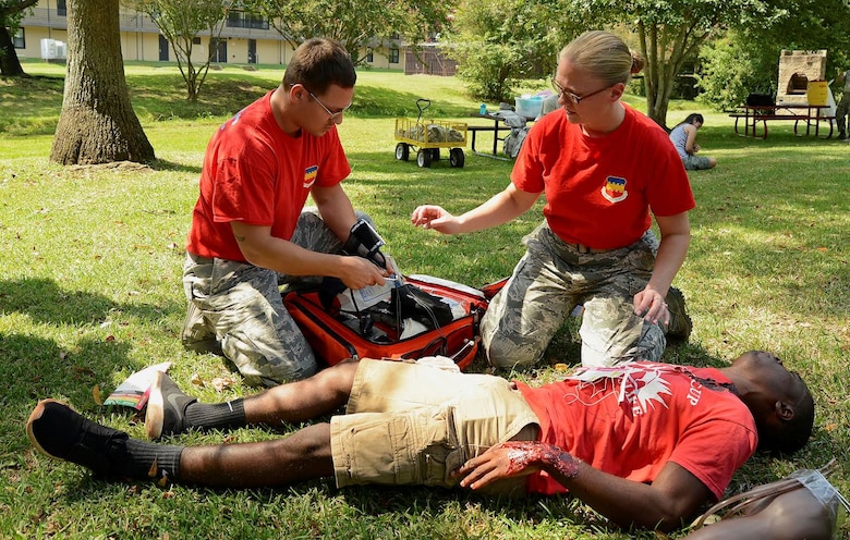 U.S. Air Force Airman 1st Class Anthony Davis, 20th Medical Operations Squadron medical technician and Tech. Sgt. Kathy Cooper, 20th MDOS patient advocate, attend to Airman 1st Class Brandon Hayes, 20th Component Maintenance Squadron electronic warfare systems technician, who simulates having burns on his body during the 1st Annual Medic Games at Shaw Air Force Base, S.C., Sept. 9, 2016. This exercise was a friendly competition between eight medical teams from Shaw AFB and Joint Base Charleston, S.C.   (U.S. Air Force photo by Airman BrieAnna Stillman)  
