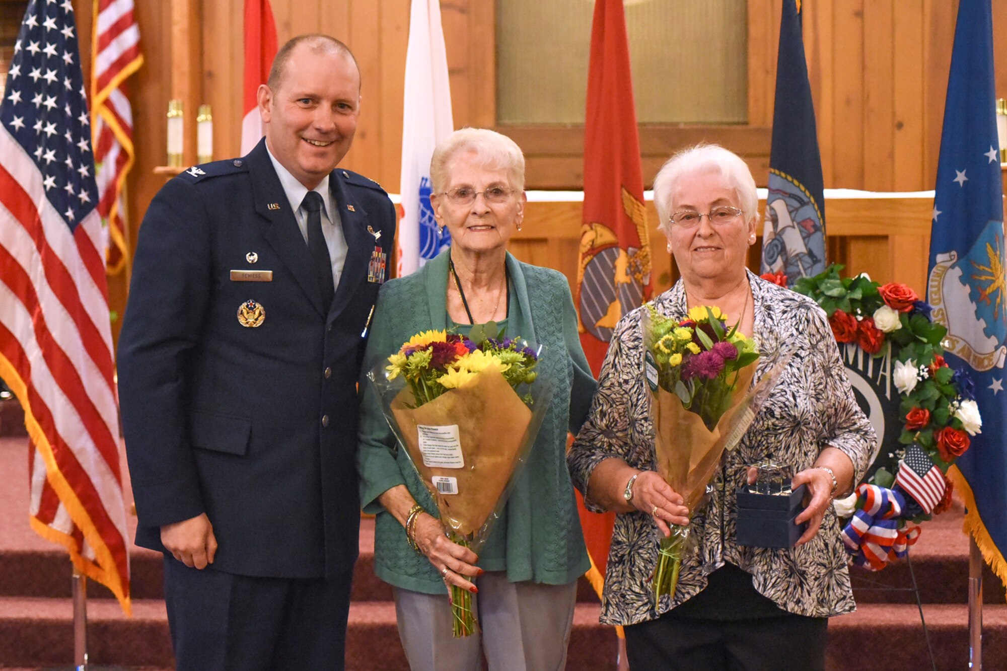 PETERSON AIR FORCE BASE, Colo. – Col. Doug Schiess, 21st Space Wing commander, presents small plaques and flowers to Ruth Wilber Sheaves and Dawn Francois, both widows of former POWs, during a POW/MIA ceremony at the base chapel at Peterson Air Force Base, Colo., Sept. 16, 2016. The ceremony was held to remember the lives lost and those missing in action. (U.S. Air Force photo by Philip Carter)