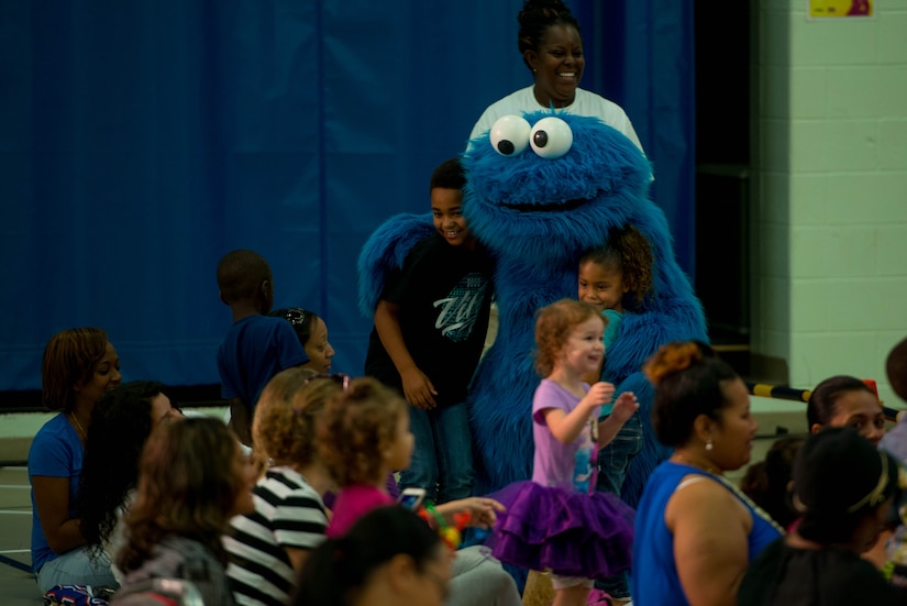 Sesame Street character, Cookie Monster, hugs and takes picture with patrons during the Sesame Street/USO Experience for Military Families tour in the Fort Eustis Youth Center at Joint Base Langley-Eustis, Va., Sept. 16, 2016. The tour is designed to help military families deal with the unique challenges they face, according to USO officials. (U.S. Air Force photo by Staff Sgt. J.D. Strong II)