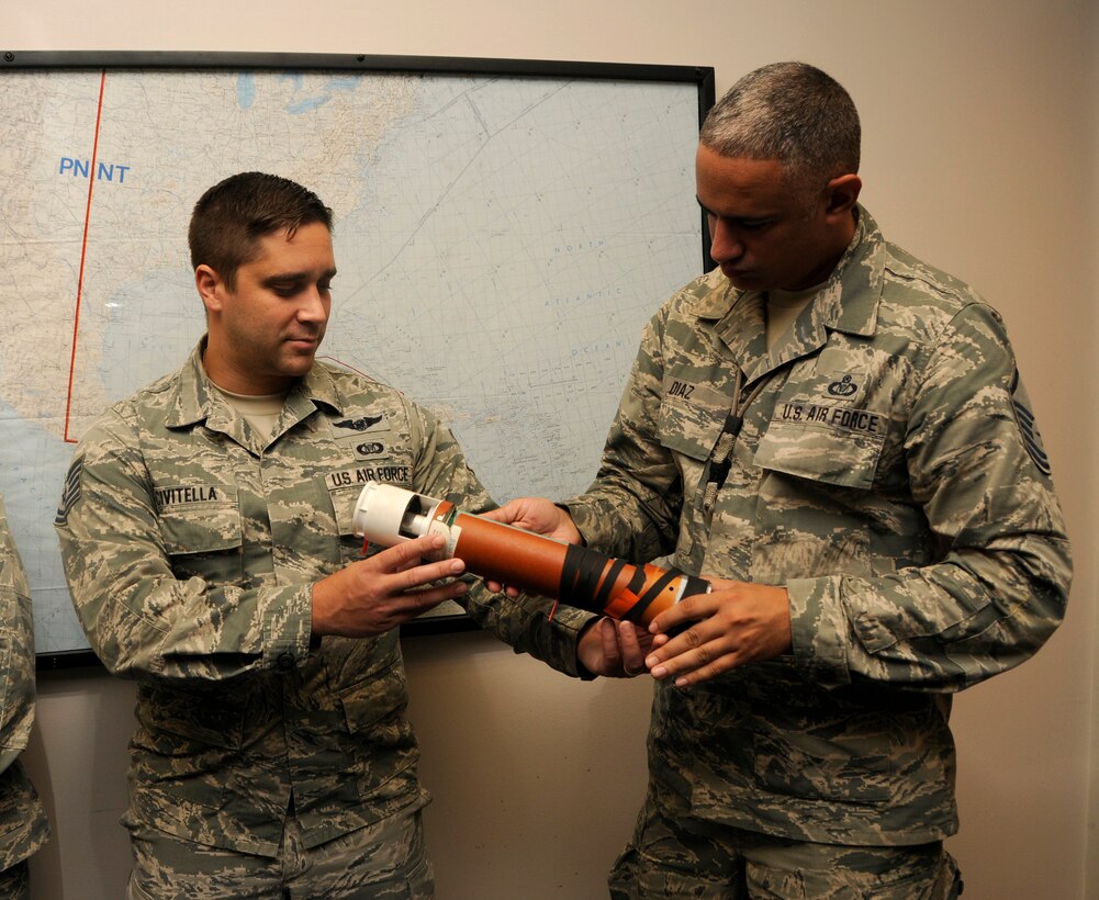 Master Sgt. Jose Diaz, right, the 482nd Fighter Wing command post superintendent, and Tech. Sgt. Nicholas Civitella, the 482nd FW command post senior controller, examine a dropsonde at the National Weather Service and the National Hurricane Center Miami, Florida, Sept. 15. The dropsonde is a device that is dropped from an aircraft  into a storm to measure tropical storm conditions and relate this information back to the aircraft. The dropsonde gathers information about the direction, pressure, temperature, and humidity of the storm. (U.S. Air Force photo by Senior Airman Aja Heiden)