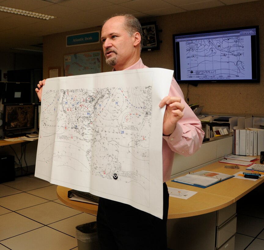 Robert Molleda, a warning coordination meteorologist for the National Weather Service Miami forecast office, holds a weather map while he explains forecasting methods and models used to predict storms at the National Weather Service and the National Hurricane Center Miami, Florida, Sept. 15. The National Weather Service works to provide accurate forecasts and warnings for the protection of life and property, and enhancement of the national economy. (U.S. Air Force photo by Senior Airman Aja Heiden)