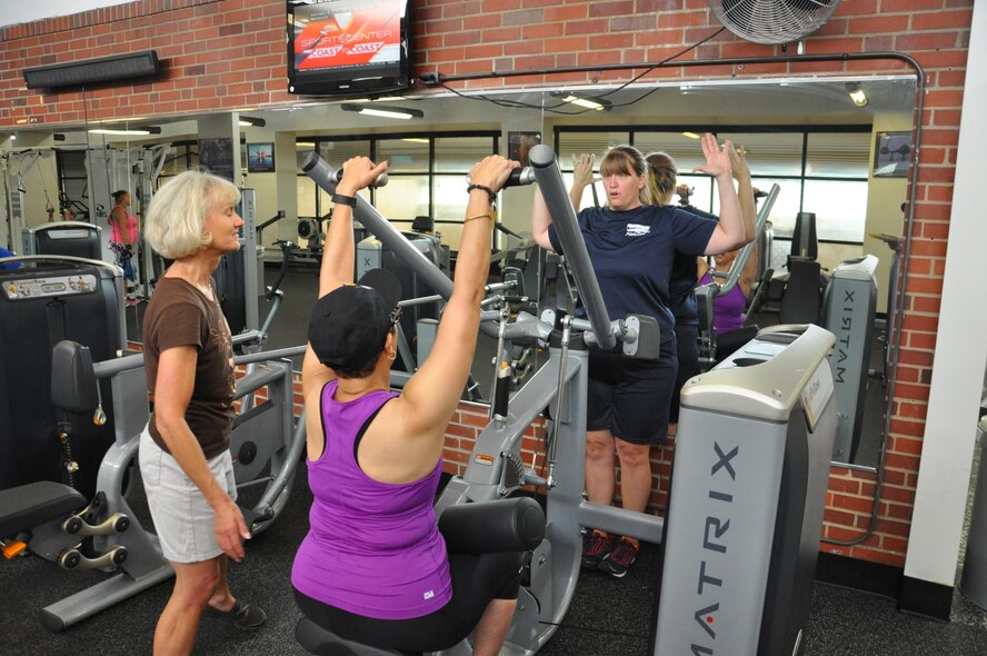 Alisha Carr, manager of Dodge Fitness Center, instructs Cindy Bauer and Cheryl Owens on how to use the new LatPullDown equipment that was installed as part of a recent 1 million equipment upgrade at Wright-Patterson Air Force Base fitness centers. (U.S. Air Force photo / W. Eugene Barnett)