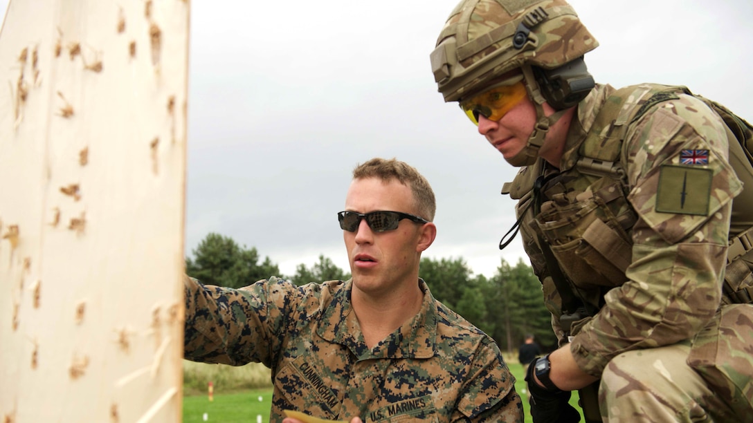 Capt. William Cunningham, a competitor with the Marine Corps Shooting Team, gives advice to a Royal Marine to improve his control of a pistol in a practice match during the Royal Marines Operational Shooting Competition, Sept. 12, 2016, The Royal Marines are competing against and building bonds with the Royal Netherlands Marine Corps and the U.S. Marines.
