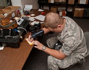 Senior Airman Zachary Hazuka, a central storage apprentice with the 5th Logistics Readiness Squadron, writes down the serial number for a chemical protection mask at Minot Air Force Base, N.D., Sept. 6, 2016. Hazuka keeps track of serial numbers for the gas mask tester on a spreadsheet in order to maintain accountability for each item. (U.S. Air Force photo/Airman 1st Class Jonathan McElderry)