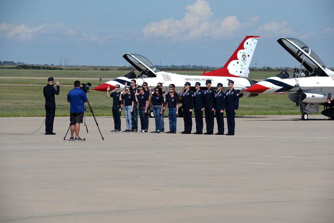 The U.S. Air Force Thunderbirds stand beside future Airmen as they enlist during the Sheppard Air Force Base, Texas, Open House and Air Show, Sept. 17, 2016. The Thunderbirds are the Air Force’s demonstration team that showcase the decisive combat power, precision and professionalism of the aviators, maintenance and support Airmen, placing emphasis on recruiting and building public trust and support for the Air Force’s mission. (U.S. Air Force photo by Senior Airman Kyle E. Gese)