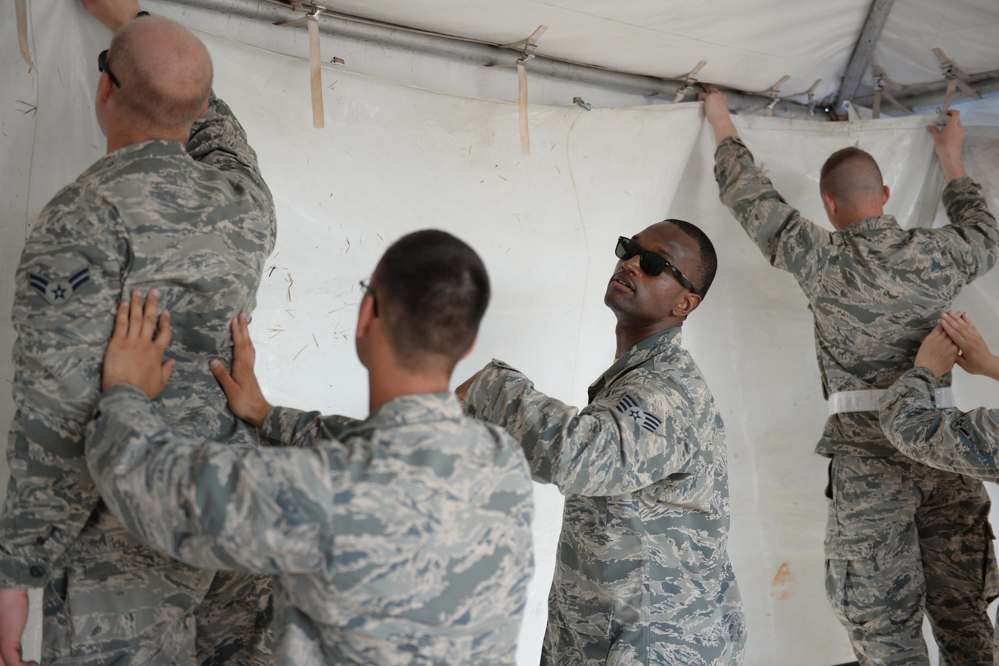 Staff Sgt. Isaac Adimora, 82nd Medical Group aerospace medical technician, aids Airmen resetting various tents for the Sheppard Air Force Base, Texas, Open House and Air Show, Sept. 18, 2016. More than 2,000 Airmen in Training gathered to help reset the base for the 75th Anniversary Air Show Celebration. (U.S. Air Force photo by Senior Airman Kyle E. Gese)