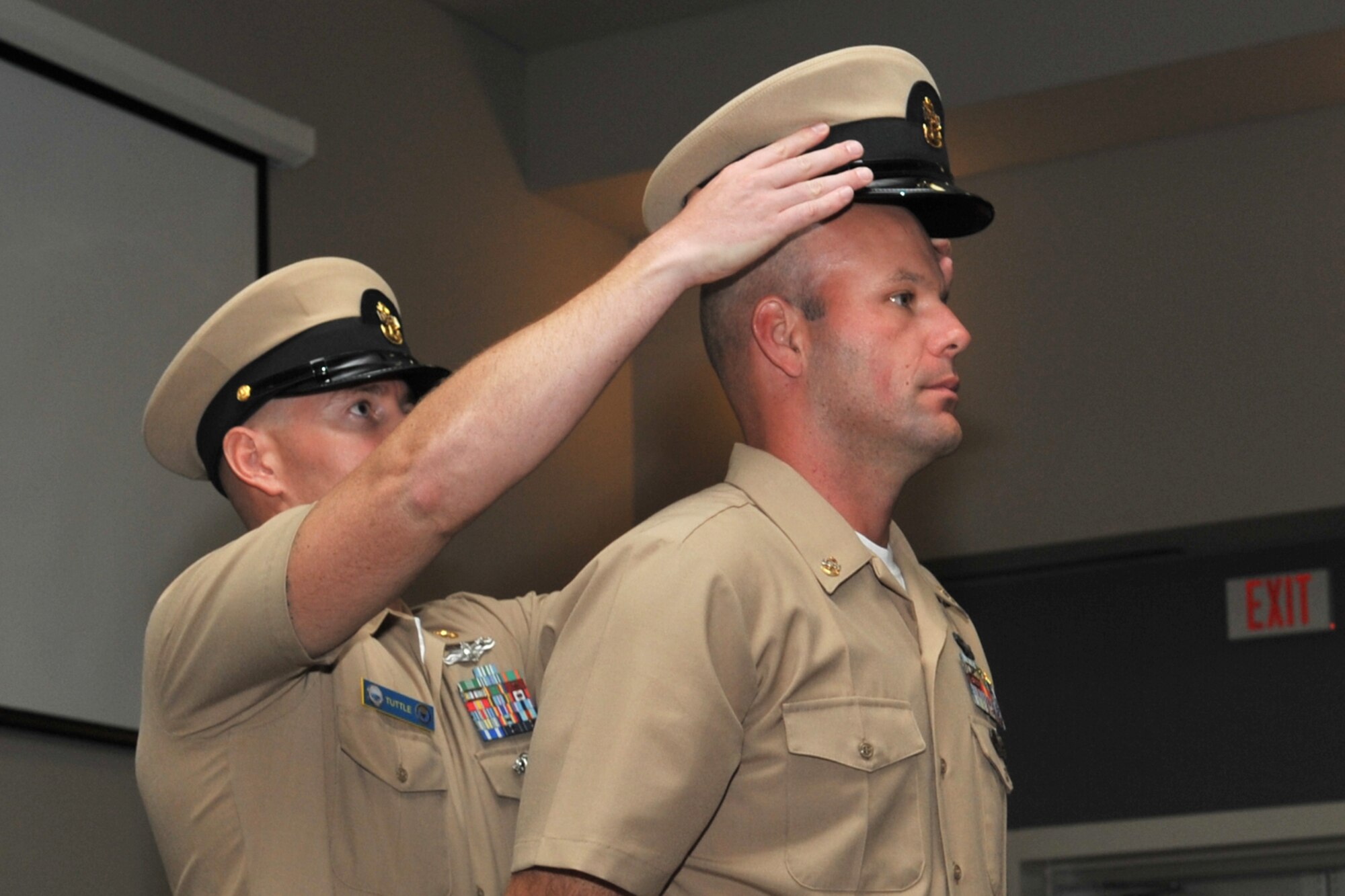 U.S. Navy Chief Petty Officer Shane Tuttle, Center for Information Warfare Training Detachment Goodfellow Assistant Officer in Charge, places a CPO combination cover atop Chief Petty Officer Steven Comstock, CIWT Naval Analysis and Reporting Course course supervisor, during the Chief Pinning Ceremony at the Event Center, Goodfellow Air Force Base, Texas, Sept. 16, 2016. The cover signifies the new position of leadership and responsibility. (U.S. Air Force photo by Staff Sgt. Laura R. McFarlane/Released)