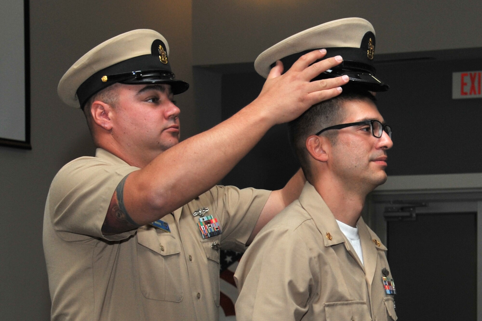 U.S. Navy Chief Petty Officer Taylor White, Center for Information Warfare Training Detachment Goodfellow 40 Dep Leading CPO, places a CPO combination cover atop Chief Petty Officer Paul Keeton, Navy Selected Reserves, during the Chief Pinning Ceremony at the Event Center, Goodfellow Air Force Base, Texas, Sept. 16, 2016. The ceremony follows a six-week training period where chief selects are challenged to strengthen leadership skills and gain a better understanding of what it means to be a Navy chief.  (U.S. Air Force photo by Staff Sgt. Laura R. McFarlane/Released)