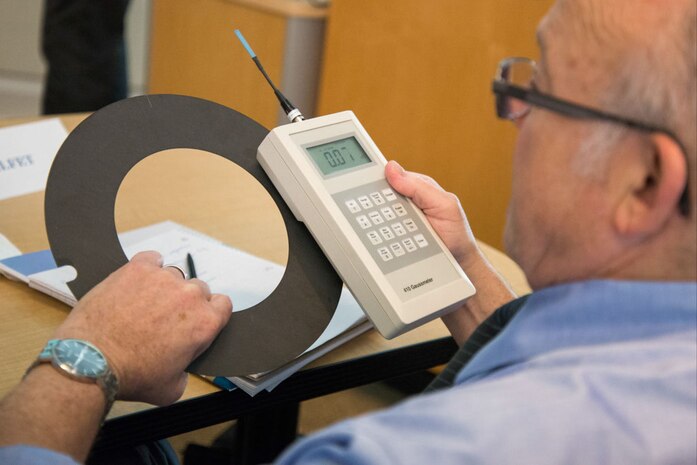 During the Innovation Discovery Event at Naval Surface Warfare Center, Carderock Divsion in West Bethesda, Md., Aug. 30, 2016, Peter Helfet, an independent business development consultant and one of the panelists, measures the magnetic field value of the large-area magnietic field sensor, a new technology presented by Dr. John Miesner, an engineer in the Structural Acoustics and Target Strength Branch. (U.S. Navy photo by Dustin Q. Diaz/Released)