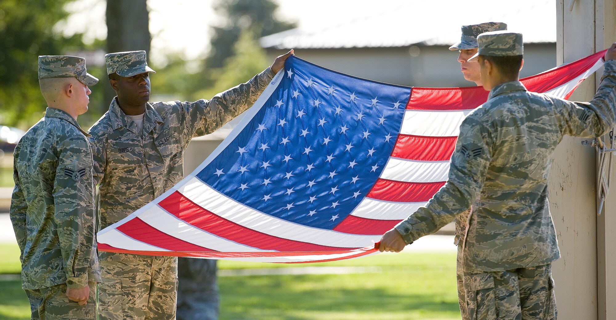 Members of the Dover Air Force Base Honor Guard prepare the American flag for folding during a retreat ceremony commemorating National POW/MIA Recognition Day Sept. 16, 2016, on Dover Air Force Base, Del. Positioned left to right, Senior Airman Kyle Kondas, 3d Airlift Squadron; Airmen 1st Class Xavier Davis and Stephen Hornik, both from the 436th Aerial Port Squadron, and Senior Airman Kaleb Powell, 436th Maintenance Squadron; presented the folded flag to Col. Scott Gaab, 436th Airlift Wing vice commander. (U.S. Air Force photo by Roland Balik)