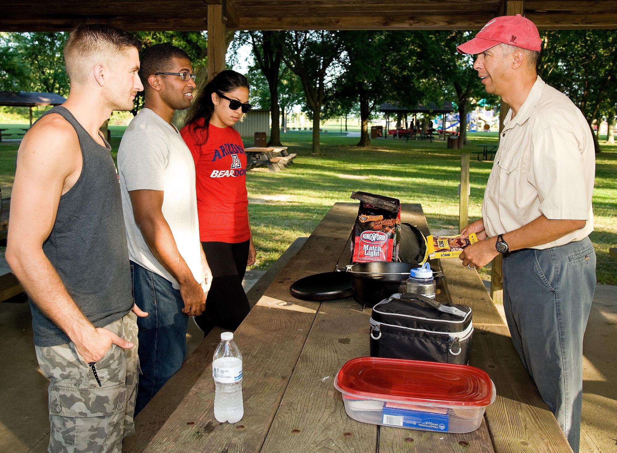 Col. Randy Boswell, 436th Mission Support Group commander, right, talks with Dorm to Gourm participants Sept. 13, 2016, at the Eagle’s Nest picnic area on Dover Air Force Base, Del. Boswell instructed the participants on the preparation of blueberry cobbler and gave tips on baking with a Dutch oven. (U.S. Air Force photo by Roland Balik)