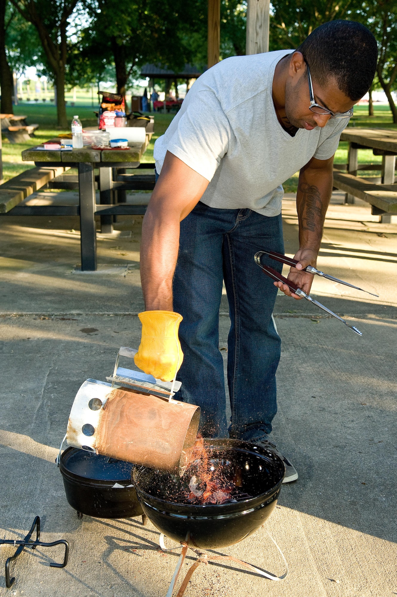 Airman 1st Class Shaughn Quarles, 436th Aerial Port Squadron, pours hot charcoals in a grill Sept. 13, 2016, at the Eagle’s Nest picnic area on Dover Air Force Base, Del. Quarles prepared the charcoal to be used for baking a blueberry cobbler prepared by Col. Randy Boswell, 436th Mission Support Group commander and Dorm to Gourm participants. (U.S. Air Force photo by Roland Balik)
