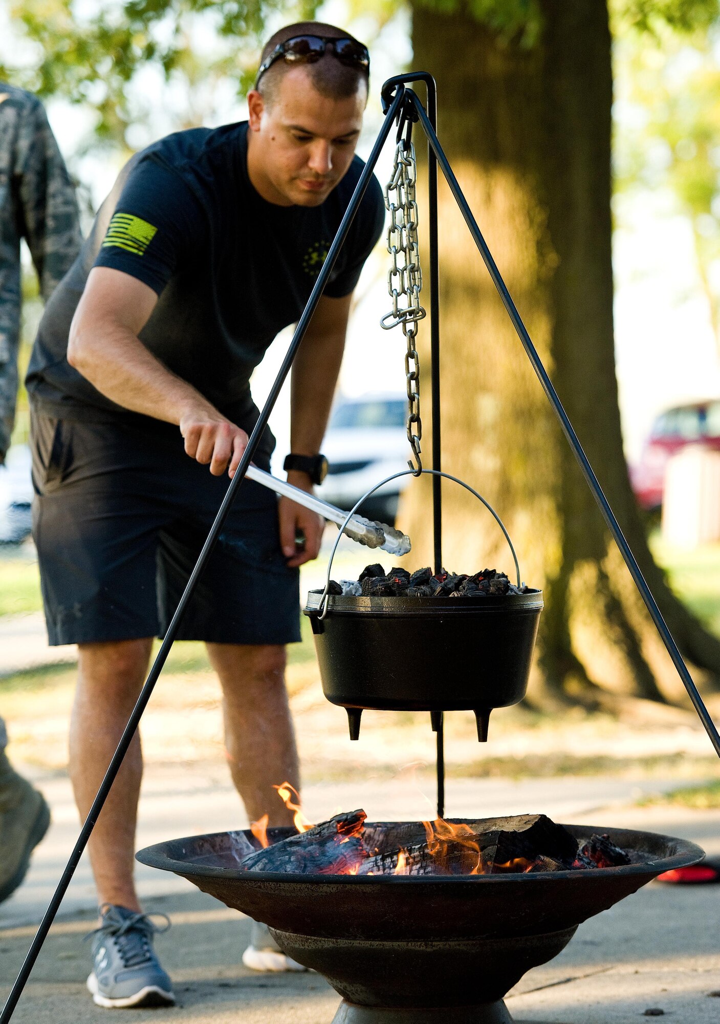 Senior Airman William Johnson, 436th Airlift Wing Public Affairs photojournalist, places hot charcoals on the lid of a Dutch oven containing his chicken recipe Sept. 13, 2016, at the Eagle’s Nest picnic area on Dover Air Force Base, Del. Johnson demonstrated how to cook a chicken in a Dutch oven to Dorm to Gourm participants. (U.S. Air Force photo by Roland Balik)