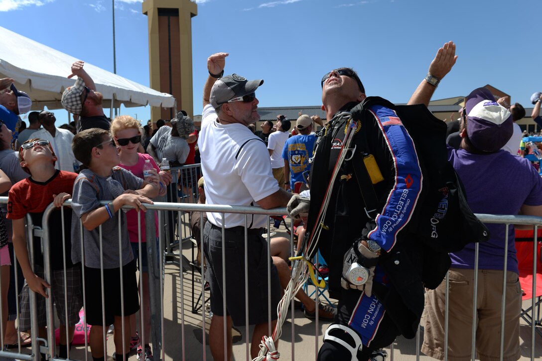Dana Bowman, retired sergeant first class with the U.S. Army and well-renowned skydiver, and other observers watch as the Air Force Wings of Blue parachute team descend on Sheppard Air Force Base, Texas, Sept. 17, 2016. Bowman and the Wings of Blue team opened the 75th Anniversary Air Show Celebration. (U.S. Air Force photo by Senior Airman Kyle E. Gese)