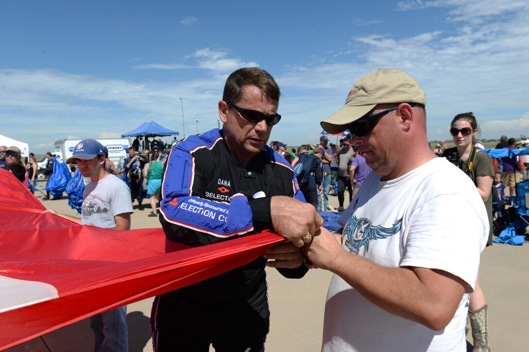 Dana Bowman, retired sergeant first class with the U.S. Army and well-renowned skydiver, folds his demonstration flag with Tony Gese, skydiving enthusiast, during the Sheppard Air Force Base, Texas, 75th Anniversary Air Show, Sept. 17, 2016. Bowman and the Wings of Blue team opened the 75th Anniversary Air Show Celebration. (U.S. Air Force photo by Senior Airman Kyle E. Gese)