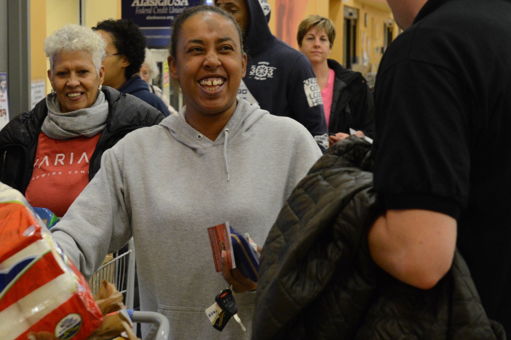Natasha Mullins, a medical technician with the 673d Surgical Squadron, receives a gift card at the Joint Base Elmendorf-Richardson commissary Sept. 16, 2016. Members of the Arctic Warrior Top Three were at various JBER locations handing out gift cards as part of the Pay It Forward Initiative. 