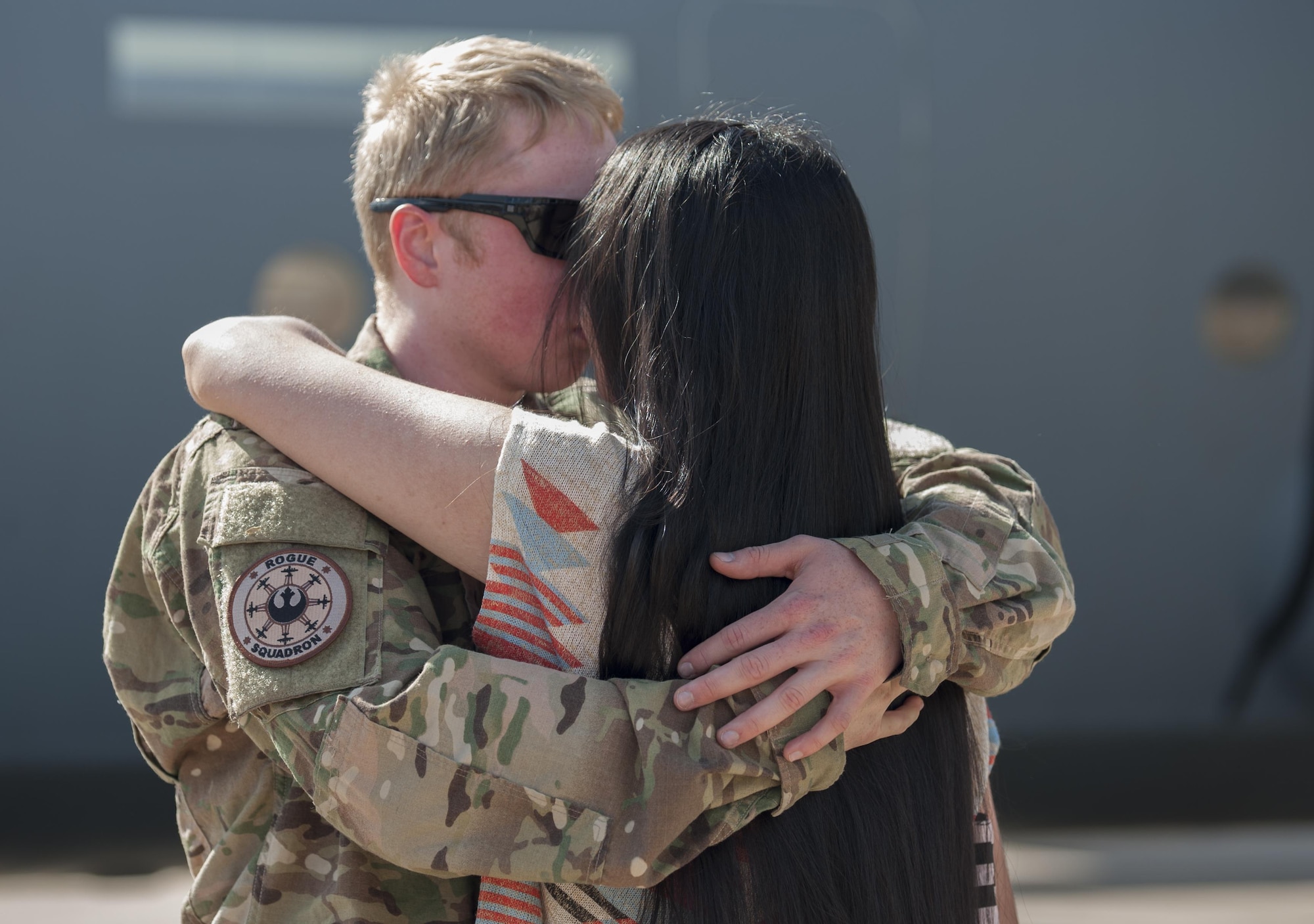 U.S. Air Force Senior Airman Derek Robertson, 317th Aircraft Maintenance Squadron aerospace journeyman, embraces his girlfriend, Sierra Webster, after returning from a deployment at Dyess Air Force Base, Texas, Sept. 19, 2016. The deployed Airmen were divided into two groups, each spending two months at Camp Lemonnier, Djibouti, Africa and Ramstein Air Base, Germany. (U.S. Air Force photo by Airman 1st Class Rebecca Van Syoc)