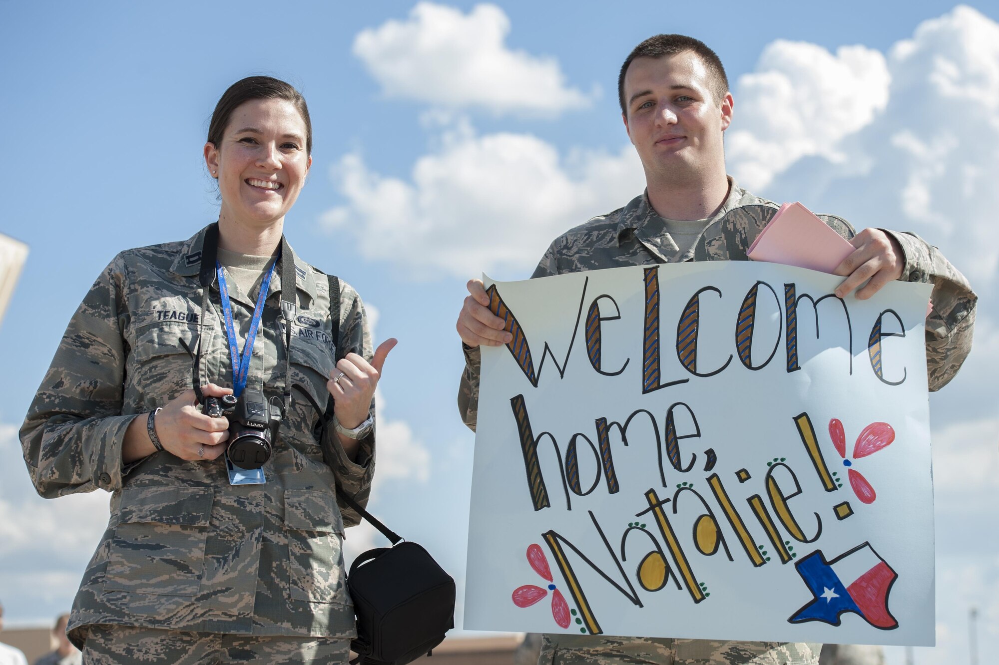 U.S. Air Force Capt. Samantha Teague and Airman 1st Class John Smith, both 317th Operation Support Squadron intelligence analysts, wait to greet returning home Airmen from deployment at Dyess Air Force Base, Texas, Sept. 19, 2016. They greeted Senior Airman Natalie Crawford, 317th OSS intelligence analyst, after she had been on a four-month deployment. (U.S. Air Force photo by Airman 1st Class Rebecca Van Syoc)